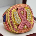 CANCER RING PINK RIBBON CHAMPION --- GOLD BODY, PINK STONES ON RIBBON, SOFTBALL/BASEBALL (Item #34-124)